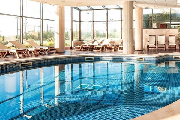 Innenpool des Punta Prima Resort & Spa mit Lounge-Sesseln und Glaswänden