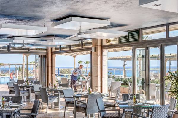 Restaurantbereich im Punta Prima Resort & Spa mit Tisch- und Stuhlplatzierung und einem Blick auf das Meer.
