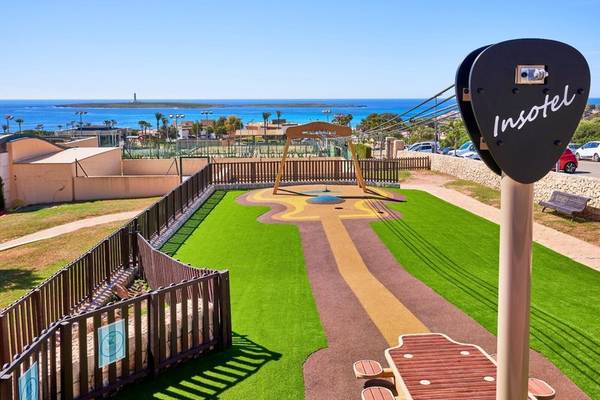 Aussicht auf den Spielplatz im Punta Prima Resort & Spa mit Blick auf das Meer und die Hotelgebäude.