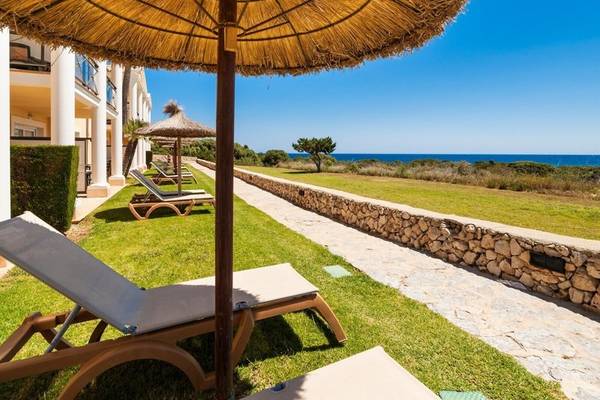 Außenbereich des Punta Prima Resort & Spa mit Liegen und Meerblick.