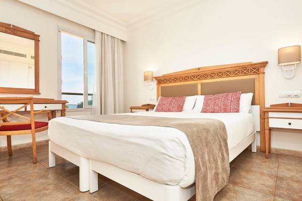 Schlafzimmer im Punta Prima Resort & Spa mit Doppelbett, Nachttischen und Panoramafenster.