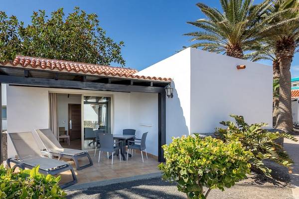 Außenbereich der Barcelo Fuerteventura Castillo Hotel mit Terrasse, Tischen und Stühlen.