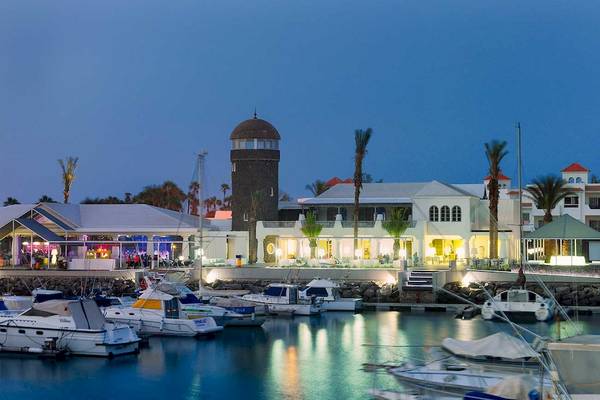 Hafen mit vielen geparkten Booten und dem Barcelo Fuerteventura Castillo Hotel im Hintergrund.