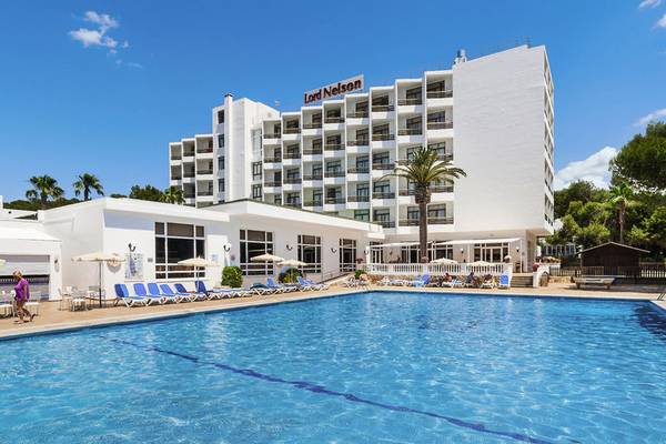 Außenbereich des Lord Nelson Hotels mit großem Pool und Sonnenliegen.