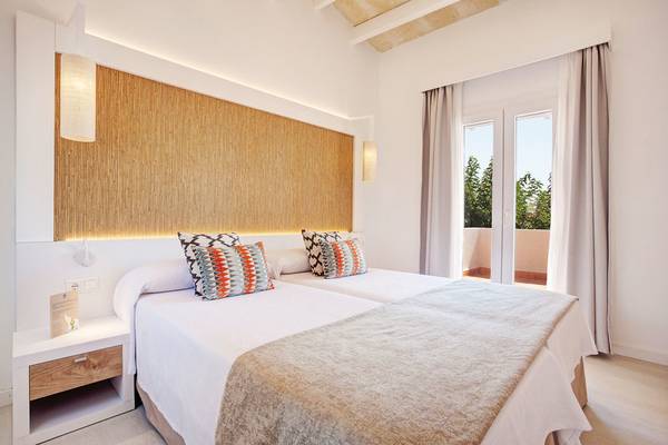 Doppelzimmer im Grupotel Aldea Cala'n Bosch mit zwei Betten, heller Wand und Terrassenaussicht