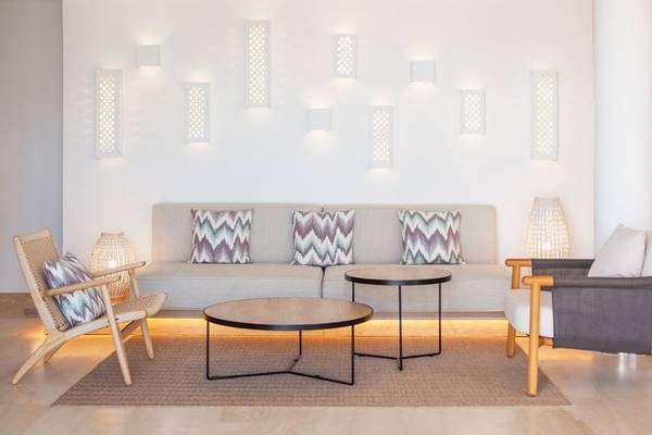 Innenbereich des Grupotel Aldea Cala'n Bosch mit einem Sofa, zwei Tischen und Stühlen.