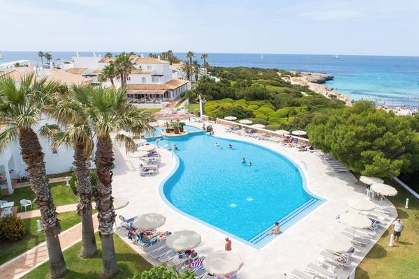 Luftaufnahme des Pools im Grupotel Aldea Cala'n Bosch Hotel mit vielen Gästen und Palmen.