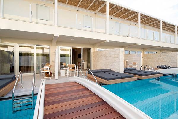 Poolbereich des Insula Alba Resorts & Spa mit Liegestühlen und Holzdeck.