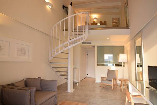 Innenbereich des Insula Alba Resorts & Spa mit Sofa, Spiraltreppe und Wohnzimmermöbeln.