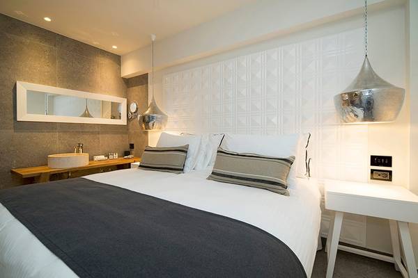 Innenansicht eines Schlafzimmers im Insula Alba Resort & Spa mit einem Doppelbett, Nachttischen und modernen Lampen.