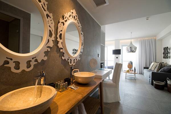 Badezimmer im Insula Alba Resort & Spa mit zwei Waschbecken und zwei Spiegeln
