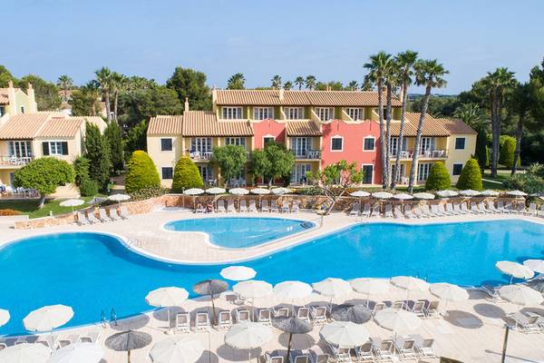 Luftaufnahme des Grupotel Playa Club Hotels mit Swimmingpool, Liegestühlen und Sonnenschirmen.
