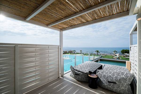 Terrasse des Insula Alba Resorts mit Blick auf den Ozean und Swimmingpool.