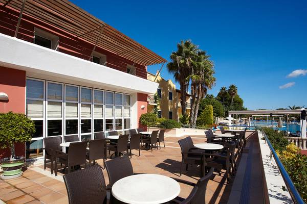 Gruppe von Tischen und Stühlen auf der Terrasse des Grupotel Playa Club Hotels.