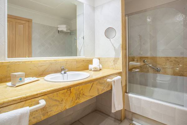 Badezimmer im Grupotel Playa Club Hotel mit Waschbecken, Spiegel und Dusche.