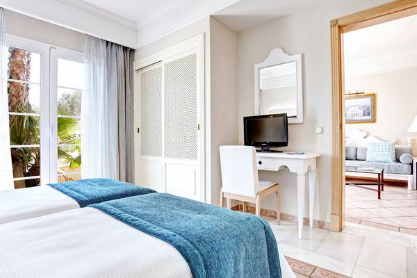 Doppelzimmer im Grupotel Playa Club Hotel mit zwei Betten, Schreibtisch und Fernseher.