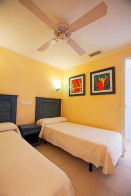 Doppelzimmer im Royal Son Bou Family Club mit zwei Betten, Deckenventilator und farbenfrohen Wänden.