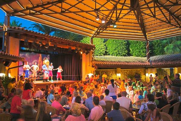 Abendliche Unterhaltung im Freien am Royal Son Bou Family Club mit einer Bühne und einem Publikum.