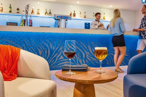 Bar im Victoria Menorca Hotel mit Getränken und Kunden hinter der Theke