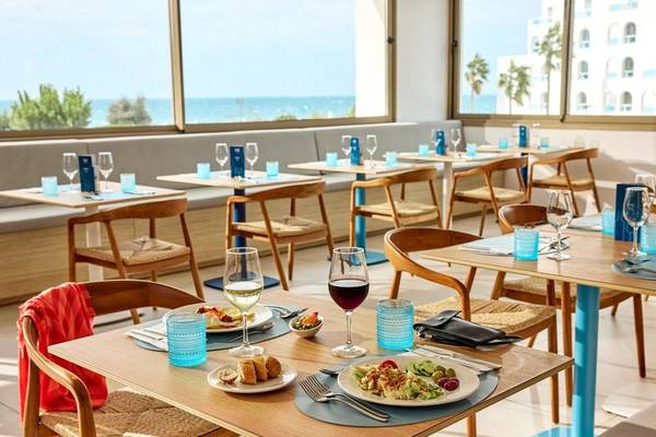 Frühstückstisch auf der Terrasse des Victoria Menorca Hotels mit Blick auf das Meer.