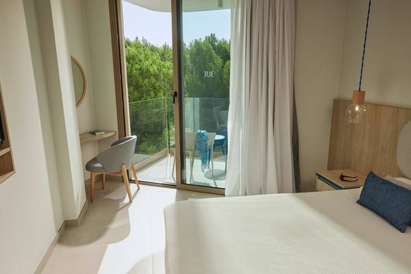 Innenansicht eines Hotelzimmers im Victoria Menorca mit Blick auf die Terrasse und die Außenmöbel.