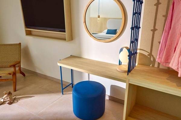 Inneneinrichtung eines Zimmers im Victoria Menorca Hotel mit Schreibtisch, Spiegel, Fernseher und Bett.