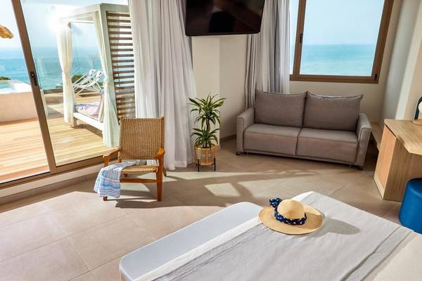 Victoria Menorca Hotelzimmer mit Meerblick, Bett, Sofa und Fernseher.