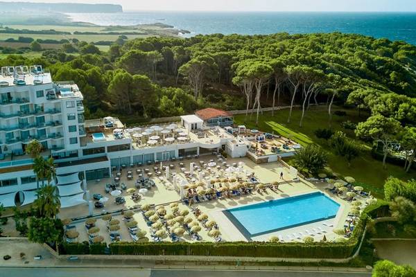 Luftaufnahme des Victoria Menorca Hotels mit Pool und Blick auf das Meer.