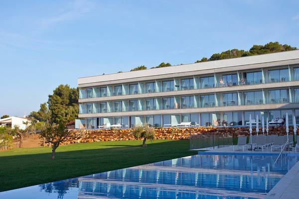 Außenansicht des Seth 55 Santo Tomás Hotels mit Swimmingpool und Sonnenliegen.