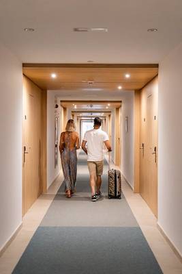 Ein Paar läuft mit Gepäck durch einen Hotelkorridor des Seth 55 Santo Tomás.