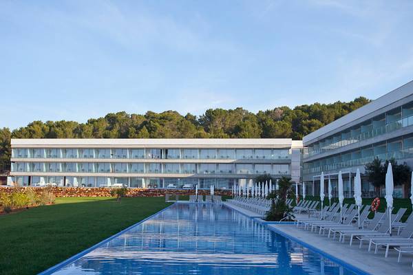 Außenansicht des Seth 55 Santo Tomás Hotels mit Swimmingpool und Liegestühlen.