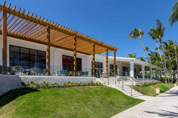 Außenansicht des Senator Puerto Plata Spa Resorts mit Holzpergola und Terrassenmöbeln.