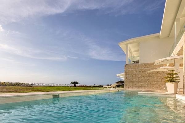 Außenbereich des Senator Puerto Plata Spa Resorts mit Pool, Loungeliegen und Sonnenschirmen.