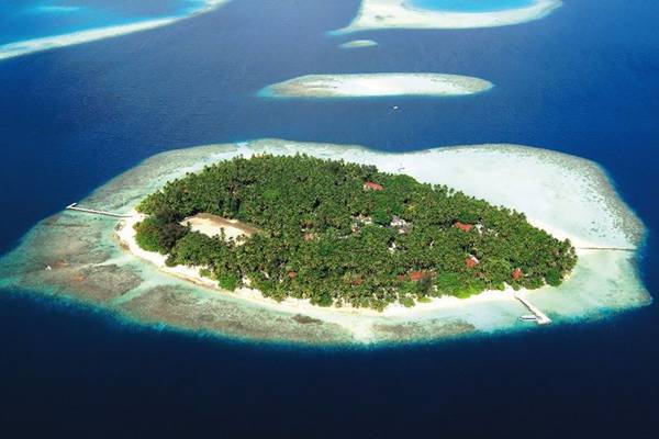 Luftaufnahme des Biyadhoo Island Resorts, einer tropischen Insel mit dichter Vegetation und weißen Sandstränden.