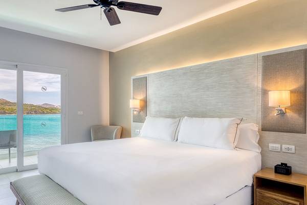 Schlafzimmer mit Meerblick im Senator Puerto Plata Spa Resort, mit Bett, Fenster und Nachttisch.
