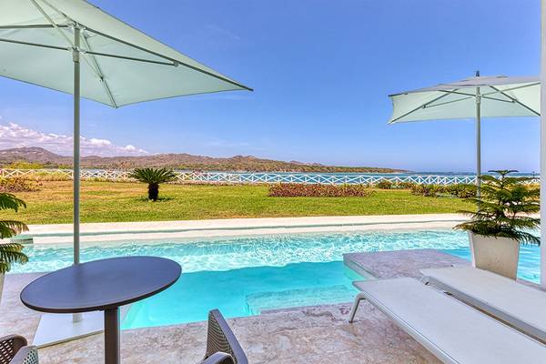 Außenbereich des Senators Puerto Plata Spa Resorts mit einem Pool, Sonnenliegen und Sonnenschirmen.