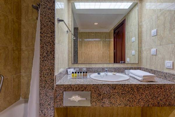 Badezimmer des Senator Puerto Plata Spa Resorts mit Badewanne, Waschbecken und Spiegel.