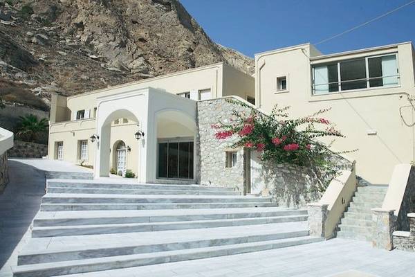 Antinea Suites & Spa Vorderansicht mit Steinmauer und Blumen an der Fassade