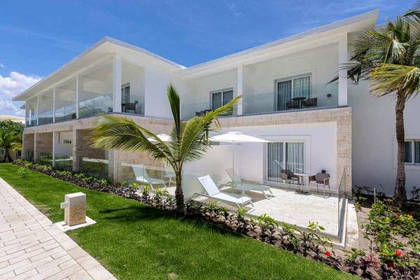 Außenbereich des Senator Puerto Plata Spa Resorts mit Palmen und Lounge-Stühlen