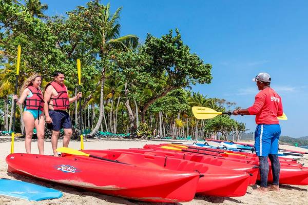 Paar in roter Kajak-Ausrüstung auf dem Senator Puerto Plata Spa Resort Strand