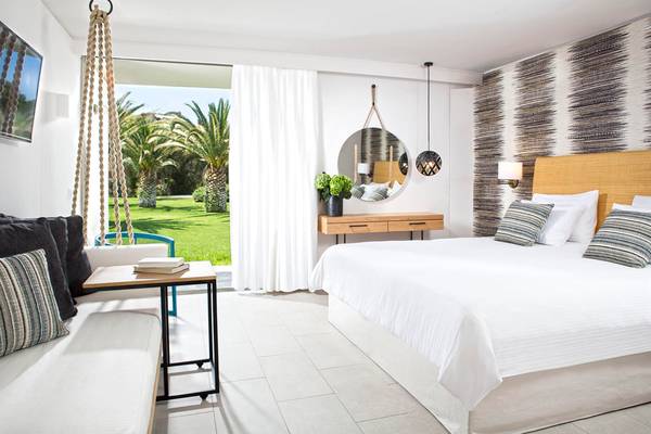 Innenansicht eines Zimmers im Agapi Beach Resort mit Blick auf einen Garten.