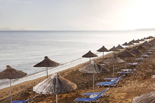 Strand mit Sonnenschirmen und Liegen am Agapi Beach Resort
