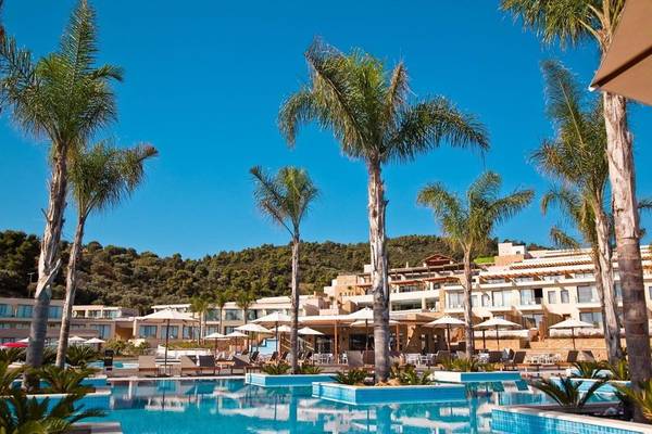 Außenpoolbereich des Miraggio Thermal Spa Resorts mit Palmen und Sonnenschirmen.