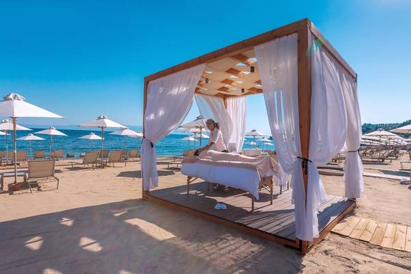 Massage im Miraggio Thermal Spa Resort auf dem Strand mit Sonnenschirmen und Lounge-Stuhl