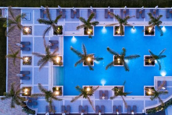 Luftaufnahme des Pools im Miraggio Thermal Spa Resort mit Palmen und Liegestühlen