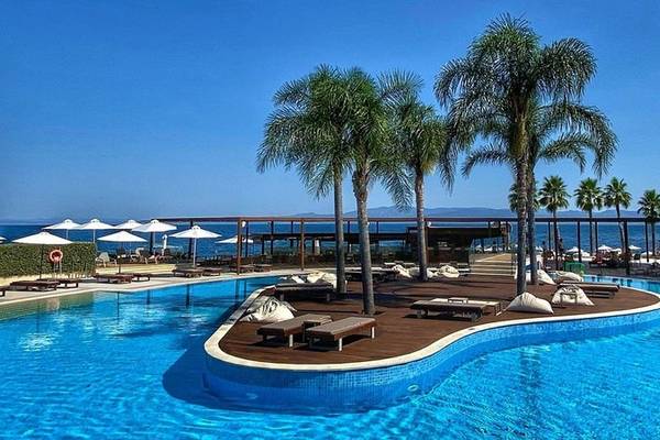 Poolbereich des Miraggio Thermal Spa Resorts mit Loungeliegen und Palmen