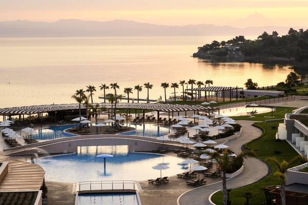 Luftaufnahme des Poolbereichs des Miraggio Thermal Spa Resorts mit einem Meer im Hintergrund.