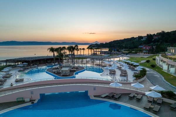 Luftaufnahme des Miraggio Thermal Spa Resorts mit Außenpools, Liegestühlen und Sonnenschirmen am Meer