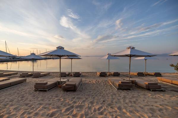 Strand des Miraggio Thermal Spa Resorts mit Liegen und Sonnenschirmen am Wasser