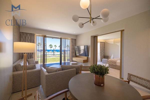 Wohnzimmer des Miraggio Thermal Spa Resorts mit Blick auf das Meer und Palmen.